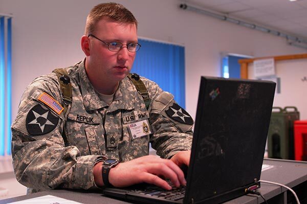 Voter in military fatigues votes on computer