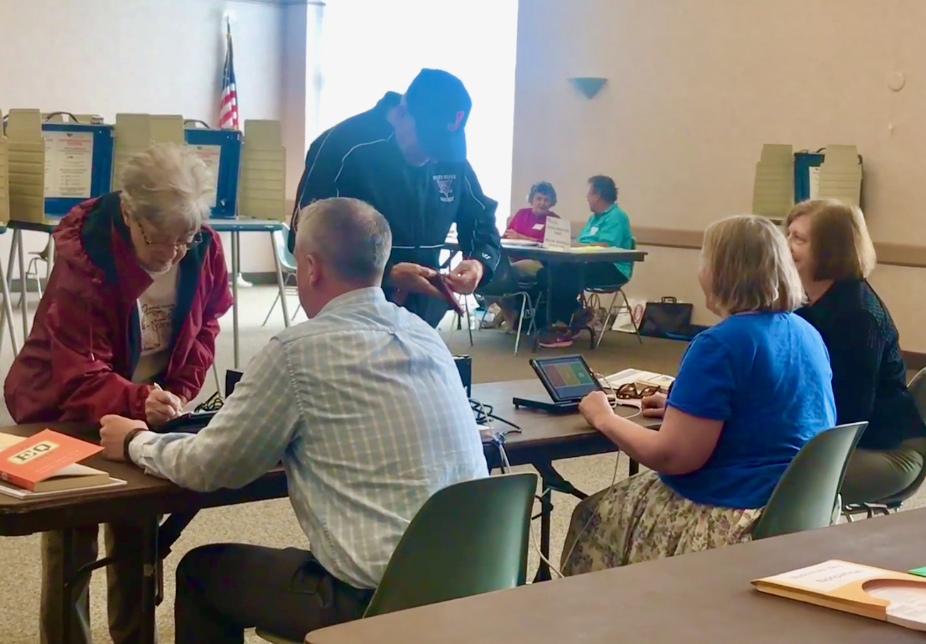 Poll workers check in voters on Precinct Central electronic poll books