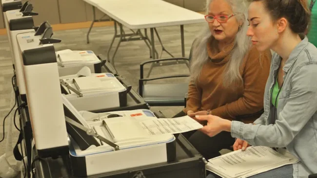 Election workers test ballot marking device