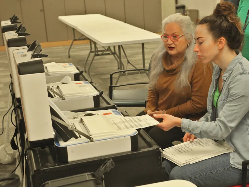 Election workers test ballot marking device