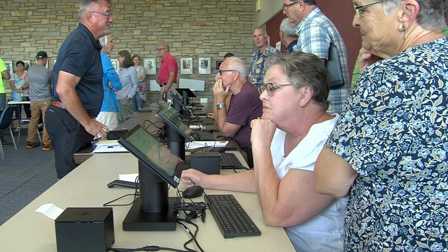 Poll workers use electronic poll book to check in voters in Wisconsin