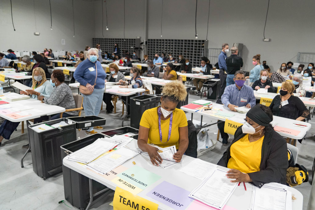 Teams of Georgia hand counters sort through ballots in a large room